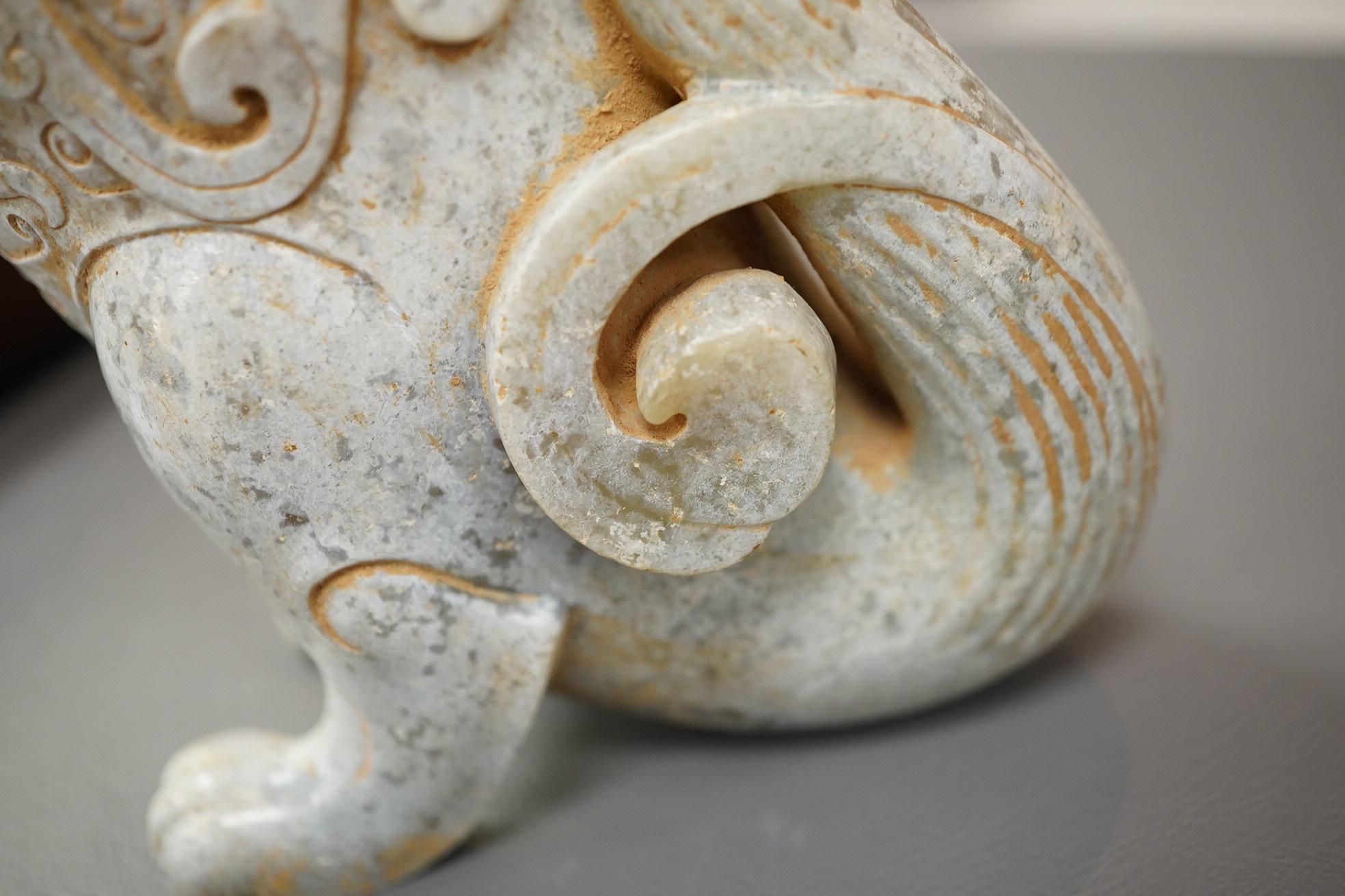 A large Chinese archaistic pale celadon and calcified jade rhyton